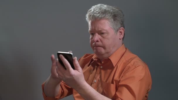 Middelbare leeftijd Man proberen om te gaan met een Smartphone en nerveus. - Video