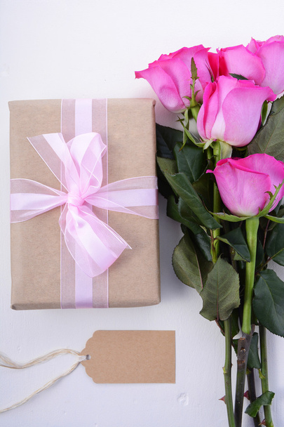 Καφέ χαρτί δώρο και ροζ τριαντάφυλλα.  - Φωτογραφία, εικόνα