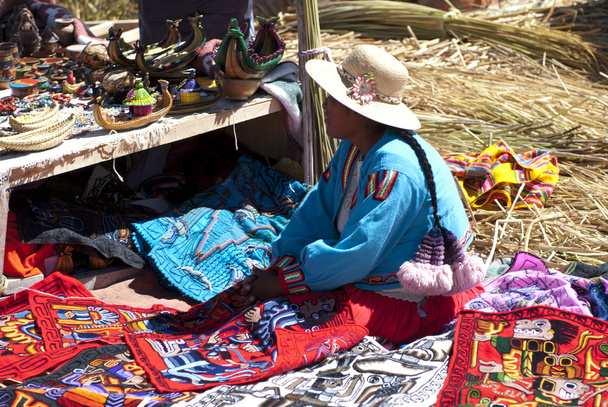 Peruvian woman selling souvenirs on floating island - Photo, Image
