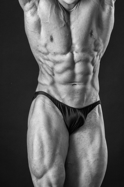 Bodybuilder posieren in verschiedenen Posen und demonstrieren ihre Muskeln. Scheitern auf dunklem Hintergrund. Männchen mit angespannten Muskeln. schöner muskulöser Körper Athlet. - Foto, Bild