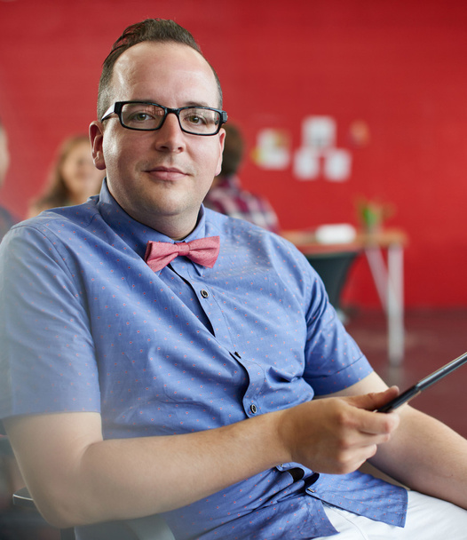 Впевнений дизайнер чоловіків, який працює на цифровому планшеті в червоному творчому офісному просторі
 - Фото, зображення