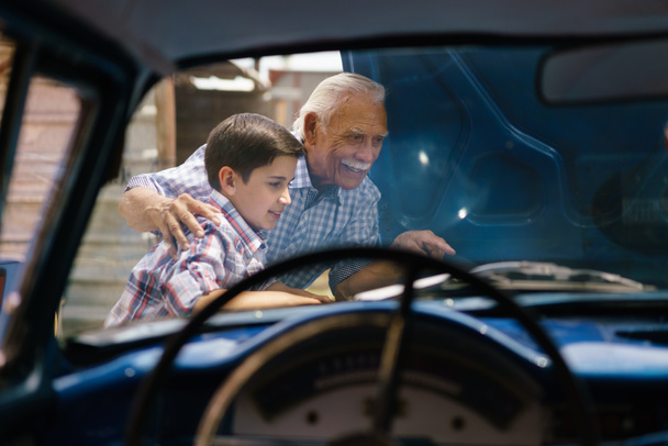 Chłopiec z dziadka Szukam silnika samochodu starszego człowieka - Zdjęcie, obraz