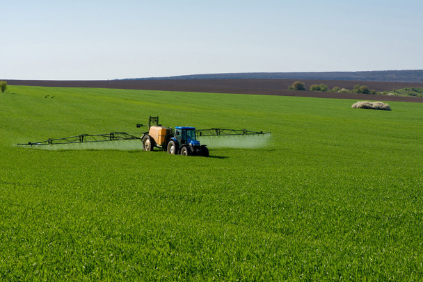 Traktor permetező peszticid búzamezőn - Fotó, kép