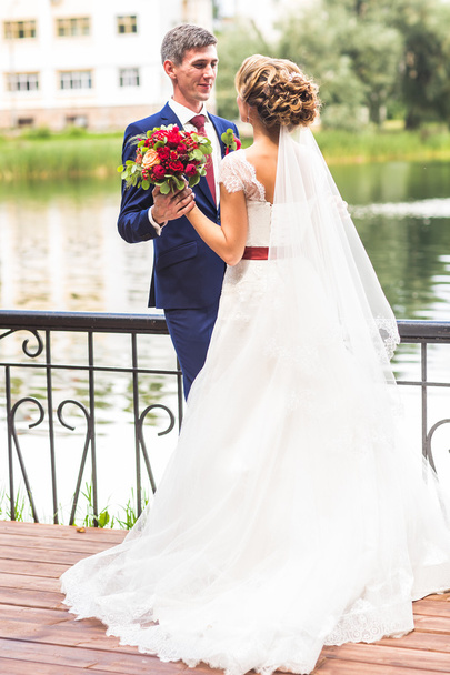 Beautiful bride and groom embracing  on their wedding day outdoors - Photo, Image