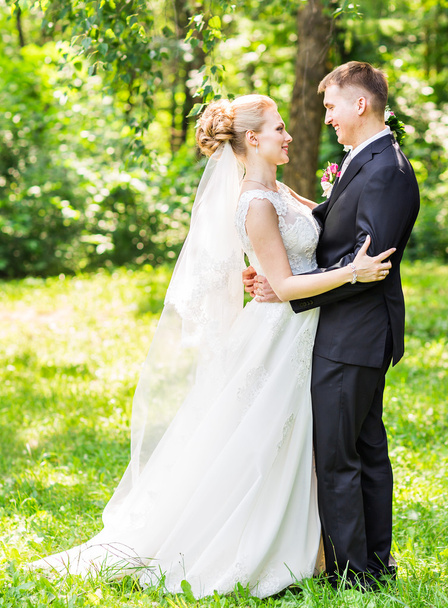 Bride and groom at wedding Day walking Outdoors. Happy Newlyweds  embracing. Loving couple. - Fotografie, Obrázek