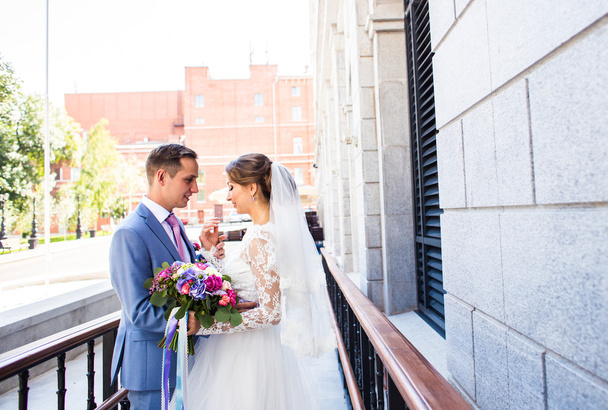 Onu açık havada kucaklayan Düğün çifti, sarılma bir buket çiçek, holding gelin damat - Fotoğraf, Görsel