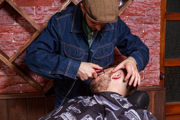 Le coiffeur cisaille le client. Le maître travaille sur un chemin le client
. - Photo, image