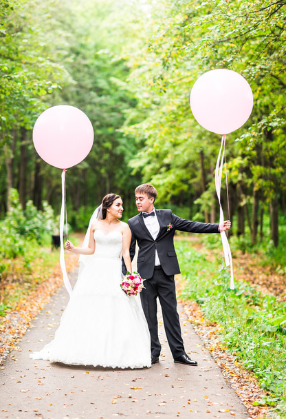 весілля пара обіймає, наречена тримає букет квітів, наречений обіймає її на відкритому повітрі
 - Фото, зображення