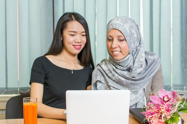 Aasian ja muslimien tytöt työskentelevät kannettavan tietokoneen
 - Valokuva, kuva