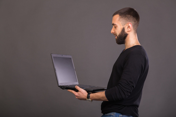 O cara com o laptop em um fundo cinza
 - Foto, Imagem