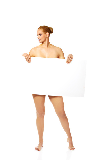 Sexy naked blonde holding empty board - Фото, изображение
