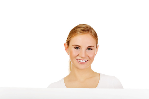 Happy young woman with blank billboard - Foto, Imagen