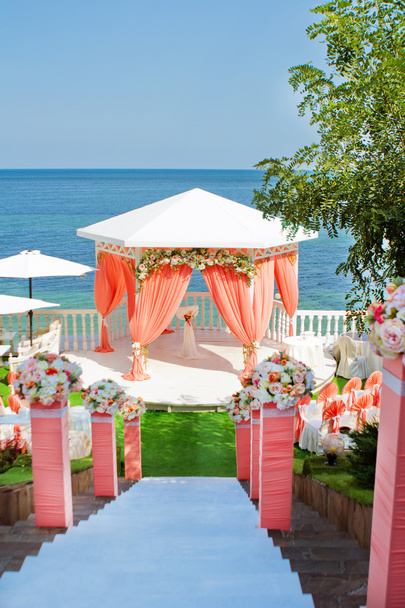 Rosafarbener Hochzeitsbogen am Meer - Foto, Bild
