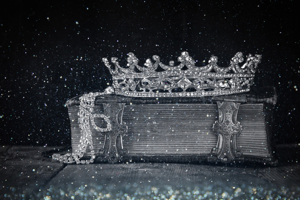low key image of decorative crown on old book - Φωτογραφία, εικόνα