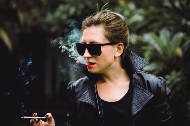 Beautiful woman smokes a cigarette. - Foto, Imagen