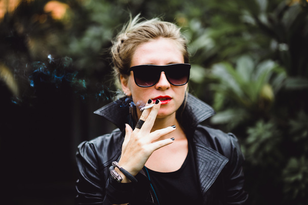 Beautiful woman smokes a cigarette. - Valokuva, kuva