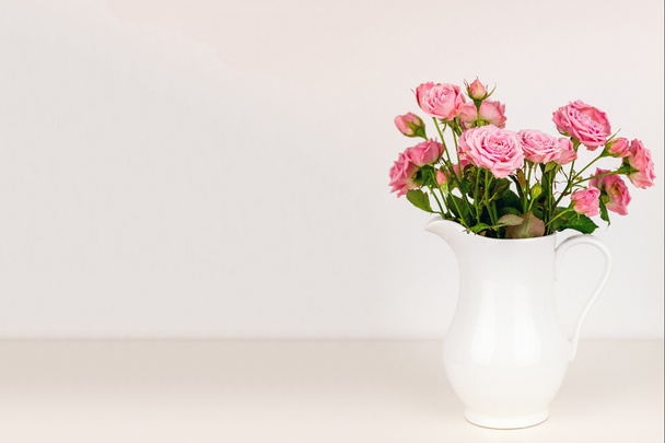 Pink flowers in white jug. - Foto, afbeelding