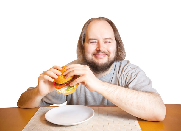 Un jeune homme va manger un hamburger. Isolé sur fond blanc
. - Photo, image