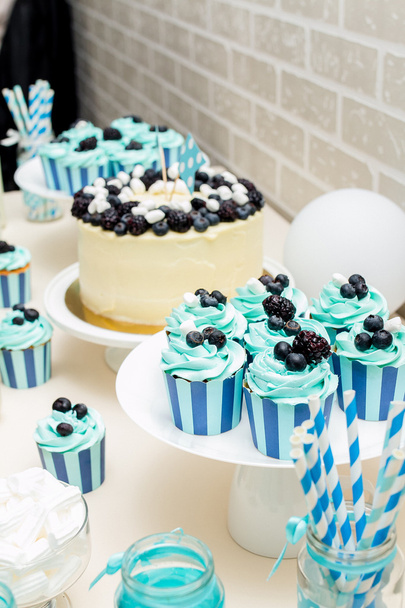  Turquoise candy bar zone met een taart en een prachtig versierde cupcakes op een kinderfeest - Foto, afbeelding