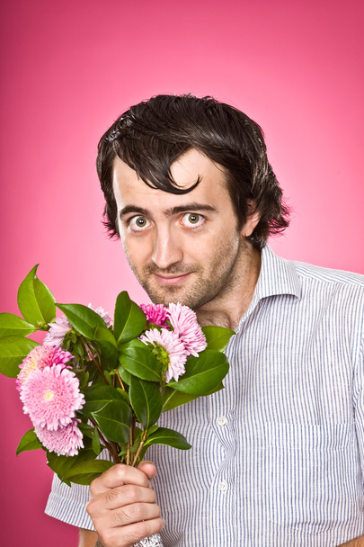 funny psychopathic nerd with flowers isolated on pink - Photo, Image