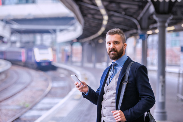 businessman with smartphone waiting for train - Zdjęcie, obraz