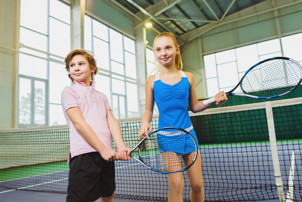Children playing tennis and posing indoor - Фото, изображение