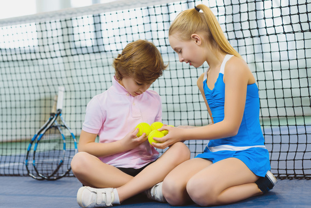 children having fun and resting on the tennis court - Фото, изображение