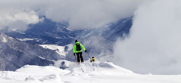 Freeriders on off-piste slope and mountains in mist - Φωτογραφία, εικόνα