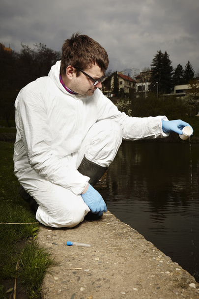 Collecting sample of potentionally contaminated water - Valokuva, kuva