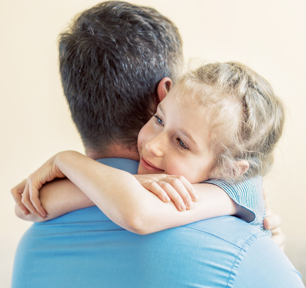 Счастливая маленькая девочка обнимает его отца
. - Фото, изображение