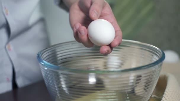 Příprava jídla. Rozbít vejce. Přísady pro pečení. Vejce do skla mísy - Záběry, video
