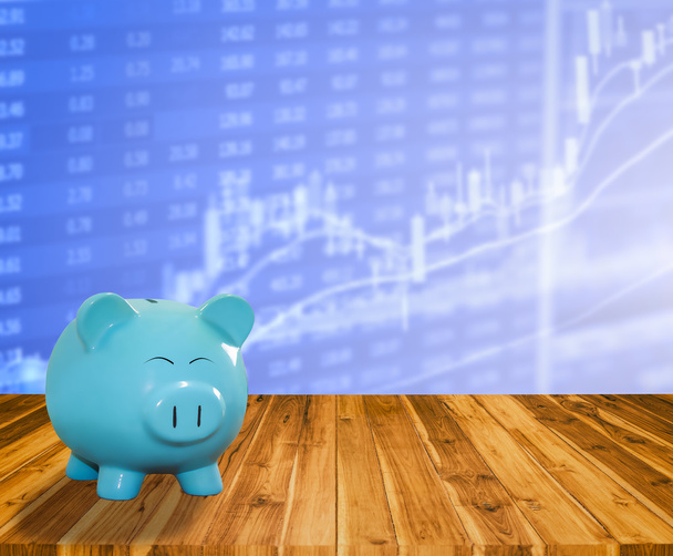 Τράπεζα μπλε χοίρου σε ξύλο φόντο με θολούρα ΩΡΑ χρηματιστηριακή αγορά - Φωτογραφία, εικόνα