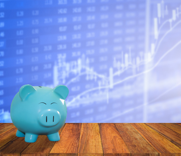 Τράπεζα μπλε χοίρου σε ξύλο φόντο με θολούρα ΩΡΑ χρηματιστηριακή αγορά - Φωτογραφία, εικόνα