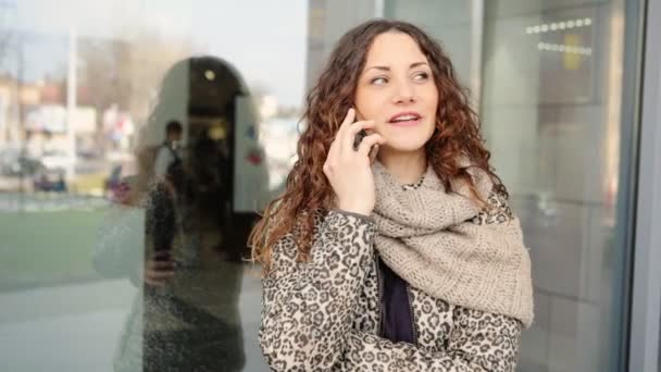 Jonge aantrekkelijke vrouw praten over de mobiele telefoon in de straat. - Video