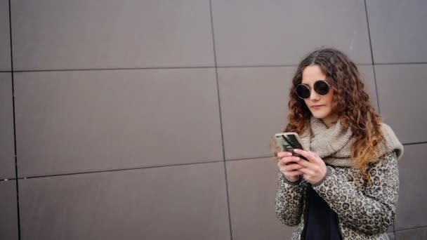 Young woman wearing sunglasses happy to get a message from his boyfriend. - Materiaali, video
