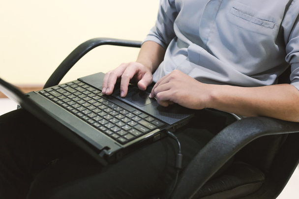 Adult man sit and typing laptop on your leg in home office - Photo, image