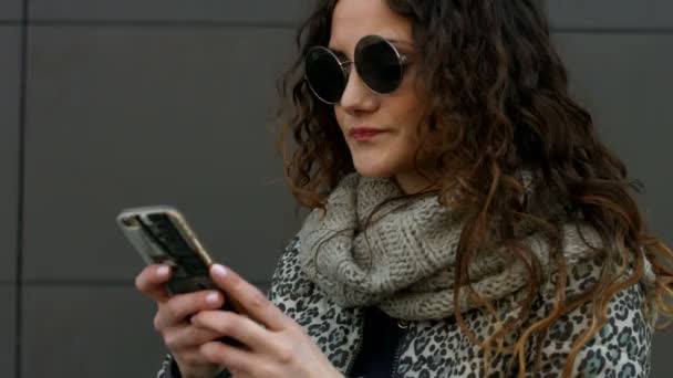 Young woman wearing sunglasses happy to get a message from his boyfriend. - Filmati, video