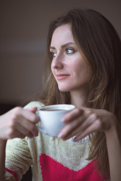 Молодая счастливая женщина держит чашку чая горячий кофе сидит кафе, образ жизни, завтрак или ужин провести время расслабляющий, здоровый, мода
 - Фото, изображение