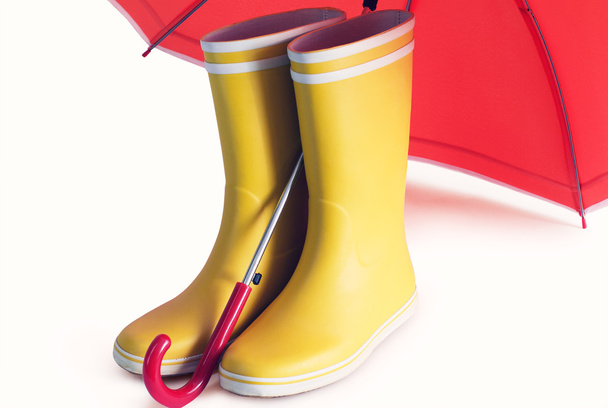 Sárga gumicsizmát és nyitott piros esernyő  - Fotó, kép