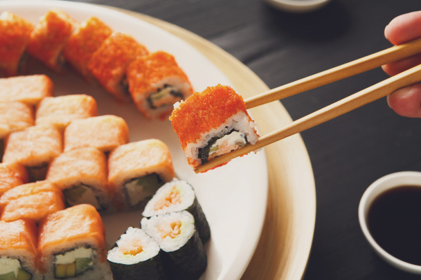 Comer rollos de sushi en el restaurante de comida japonesa
 - Foto, imagen