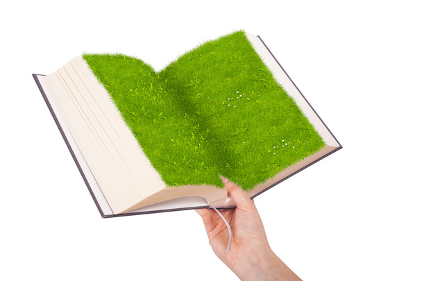 Female hand holding a ecological book with grass on white background - Photo, Image