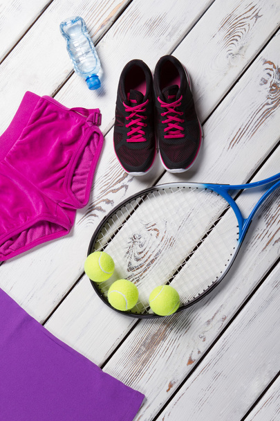 Dark sneakers and tennis racquet. - Foto, afbeelding