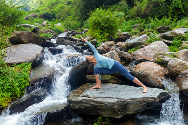 Frau praktiziert Yoga Asana Utthita Parsvakonasana im Freien - Foto, Bild