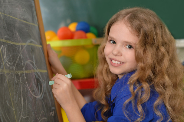 Little girl writing on chalkboard - Foto, Imagen