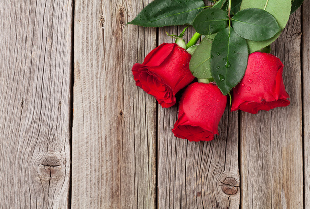 Red roses over wooden table - Fotoğraf, Görsel