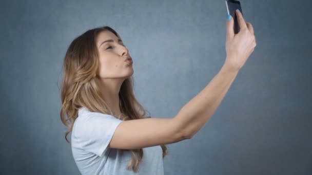 Beautiful brunette girl taking selfie in studio. - Imágenes, Vídeo