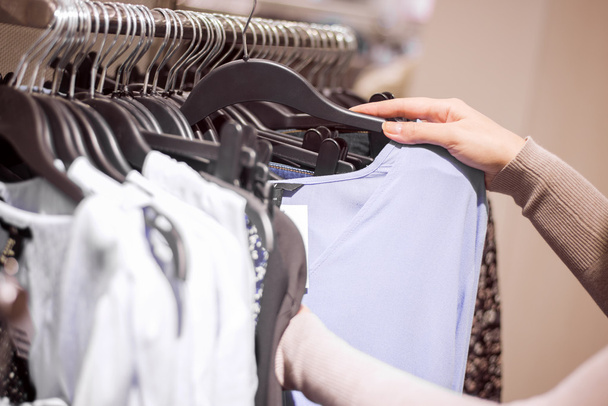 Mulher selecionando roupas na loja
 - Foto, Imagem