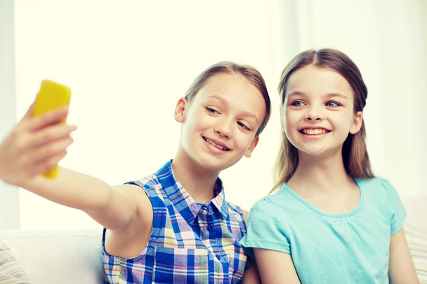 happy girls with smartphone taking selfie at home - Zdjęcie, obraz