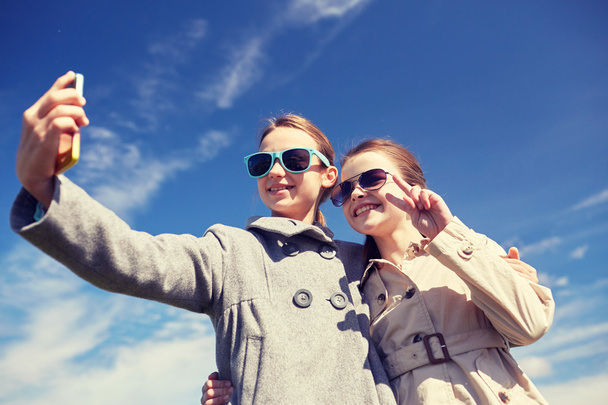 happy girls with smartphone taking selfie outdoors - Zdjęcie, obraz
