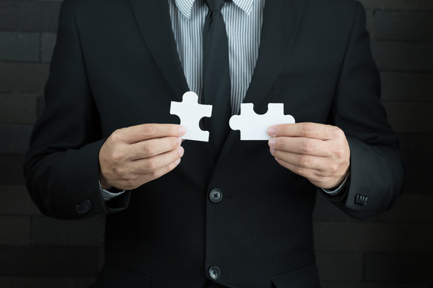 Businessmen holding two jigsaw to connect - 写真・画像